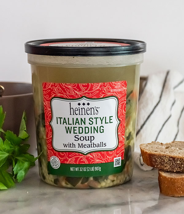 A Package of Heinen's Italian Wedding Soup with Fresh Sliced Bread and a Bundle of Fresh Herbs