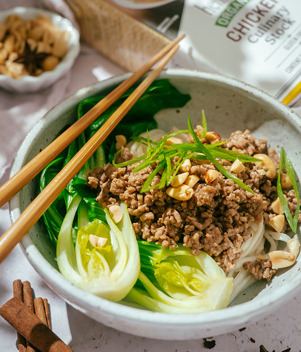 Up-close Photo of Easy Dan Dan Noodle Bowl with Bok Choy , Cooked Pork and Chop Sticks