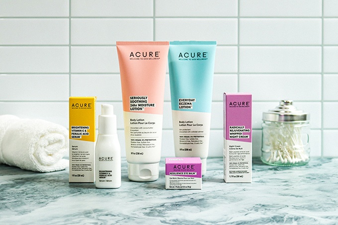 Skincare from Acure, a natural skincare brand, on a marble countertop; From left to right: Brightening Vitamin C Serum, Seriously Soothing and Everyday Eczema Lotions, Resilience Eye Balm, Radically Rejuvenating Whipped Night Cream