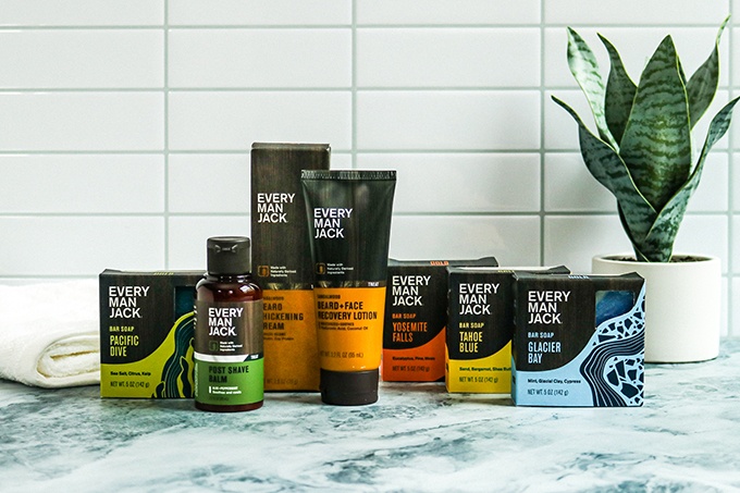 Skincare from Every Man Jack on a marble countertop; From left to right: Pacific Drive Cold Plunge Bar Soap, Post Shave Balm, Beard Thickening Cream, Beard Recovery Lotion, Yosemite Falls, Tahoe Blue, and Glacier Bay Cold Plunge Bar Soaps