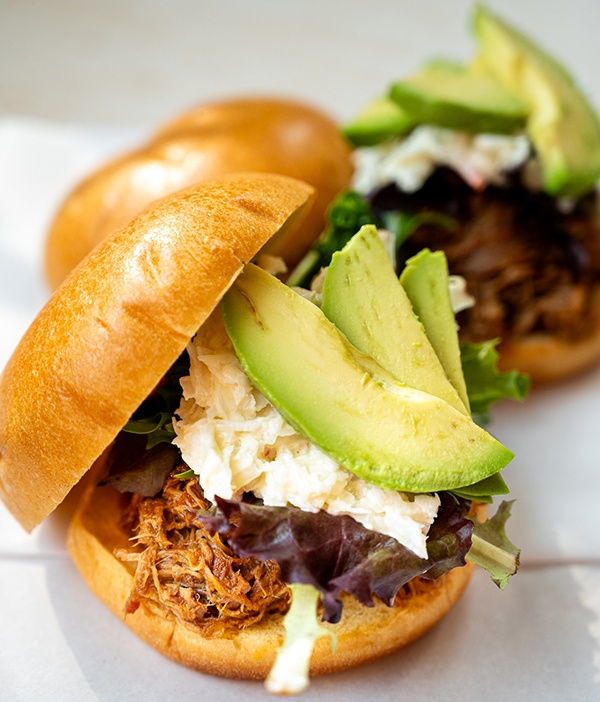 Closeup of Hatch Chile Pulled Pork Sandwich layered with avocado slices