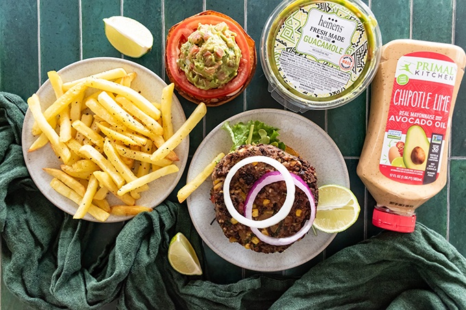 Overhead view of burger ingredients and fries, and one open top Southwest Black Bean Burger