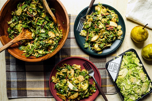 Shaved Brussel Sprouts and Pear Salad on plates and in a serving bowl