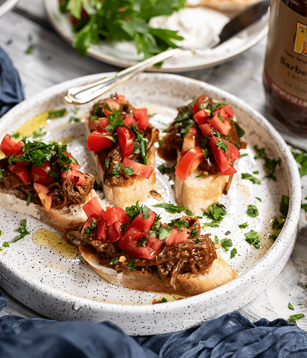 A Serving Plate with Four Pieces of Brisket Bruschetta