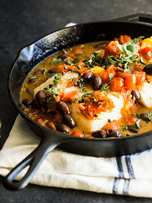 Baked Halibut with White Wine, Olives, Capers, and Tomatoes in a Cast Iron Skillet